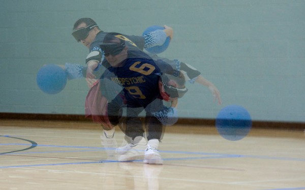 Photo has three exposures of a player throwing a goalball