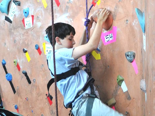 A BORP Jr. Adventurer climbs an indoor climbing wall