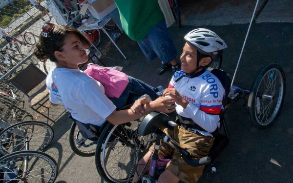 A young handcyclist gets some encouragement from a friend before a ride