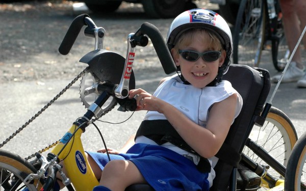 Ernesto poses for a photo on a yellow handcycle