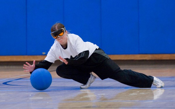 A woman dives to make a defensive stop in a goalball match