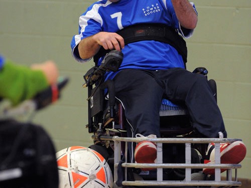 A power scoccer player pops a wheelie during a match