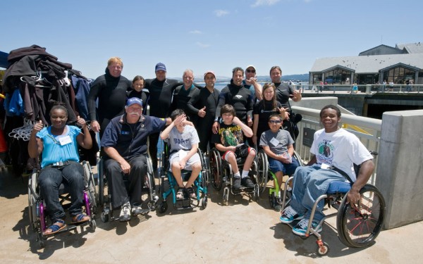 A group of BORP Junior Adventurers pose for a photo after a day of scuba diving at the Monterey Bay Aquarium