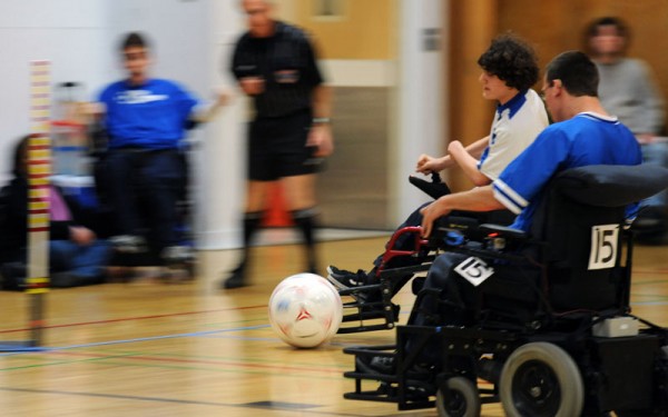 Two soccer players converge quickly on a ball