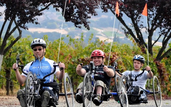 Three handcyclists ride in a row at the 2012 Revolution