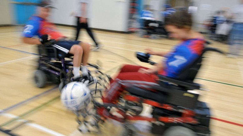 Two power soccer players are a blur of speed as they converge on a soccer ball
