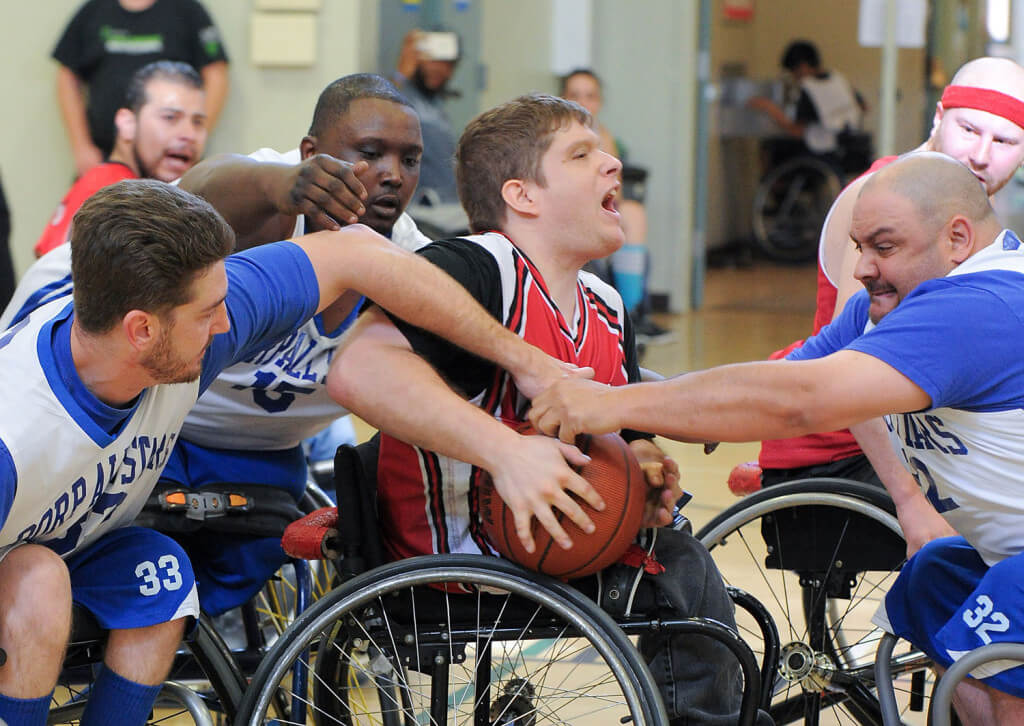 Members of the BORP All Stars wheelchair baseketball team surround an opponent