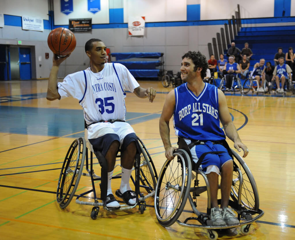 Whhelchair basketball players form BORP and Contra Costa College share a lugh during an exhibition game