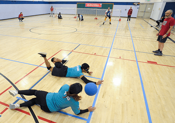 Goalball players diving to defend their goal