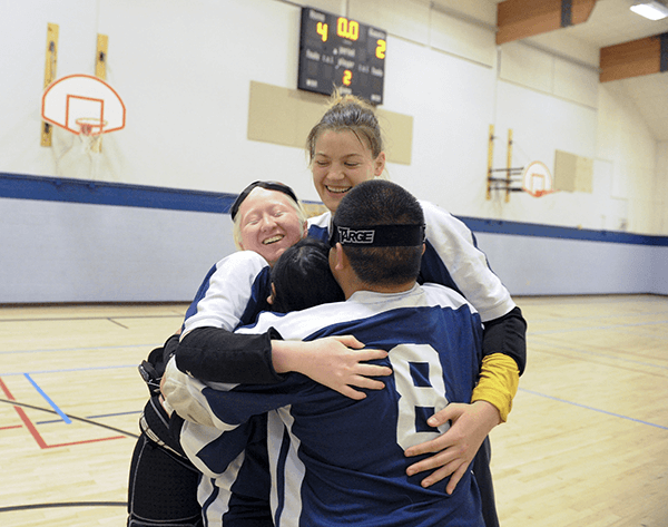 Cal Goalball players embrace, celebrating their win