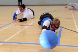 A goalball heads straight for the camera as a goalball player reaches for it