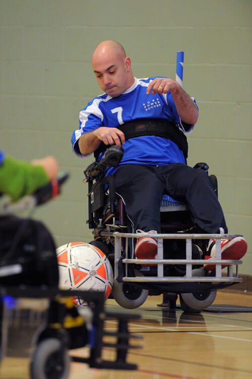 A power scoccer player pops a wheelie during a match
