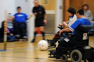 Two soccer players converge quickly on a ball