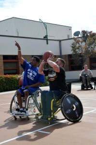 A veteran receives insruction from a BORP player on wheelchair basketball