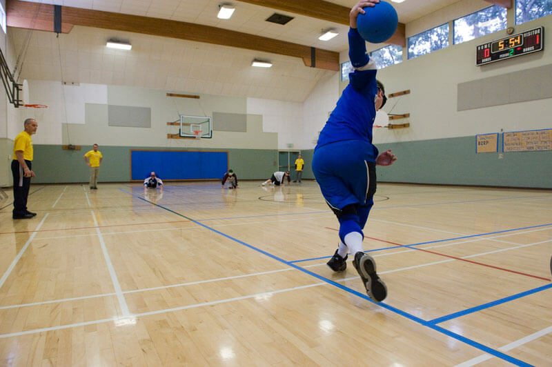 A view of a goalball player about to roll a shot down the length of the court