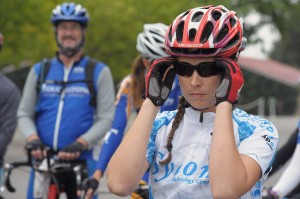 A focused cyclist puts on her sunglasses