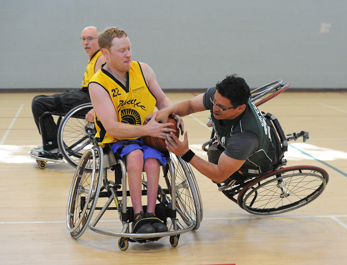 A Sacramento Cager tips over while fighting for the basketball