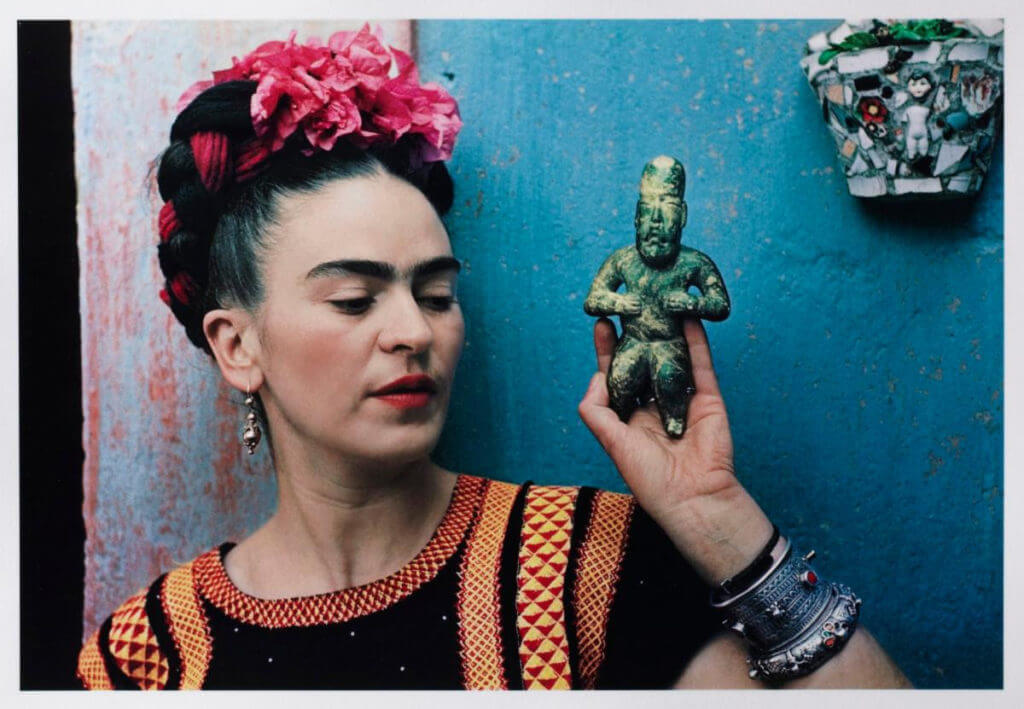 Frida Kahlo Portrait. Image: Nickolas Muray, "Frida with Olmeca Figurine, Coyoacán," 1939. Color carbon print, 10 3/4 x 15 3/4 in. (27.3 x 40 cm). Fine Arts Museums of San Francisco, Gift of George and Marie Hecksher in honor of the tenth anniversary of the new de Young museum. 2018.68.1. © Nickolas Muray Photo Archives