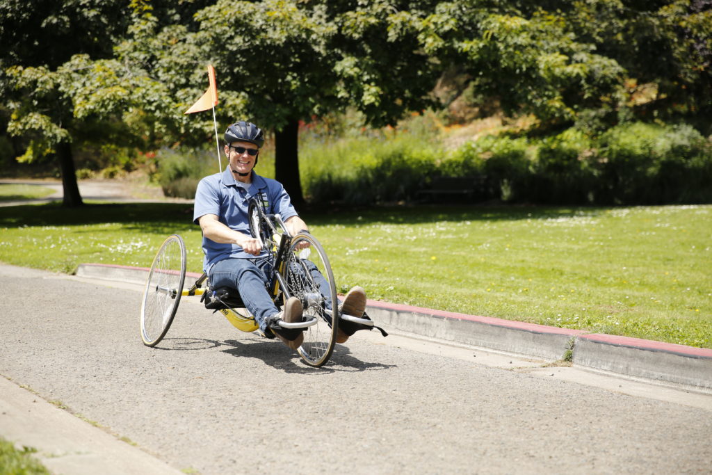 Cyclist rides through the park on his recumbent bike.