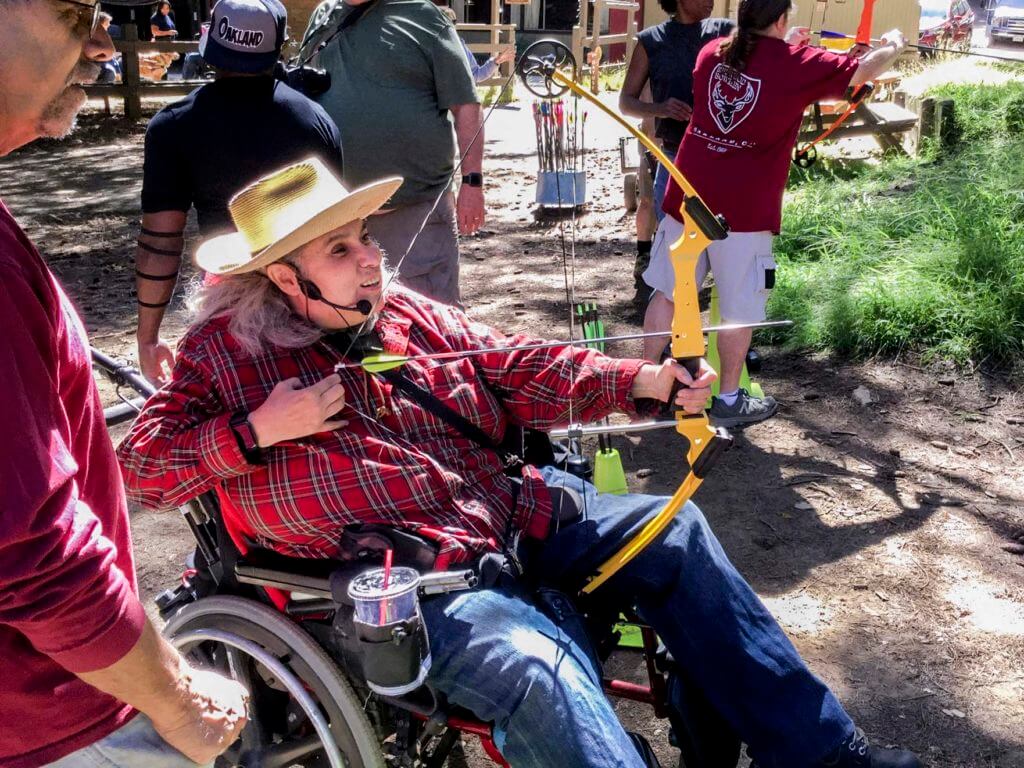 Woman in wheelchair using bow and arrow