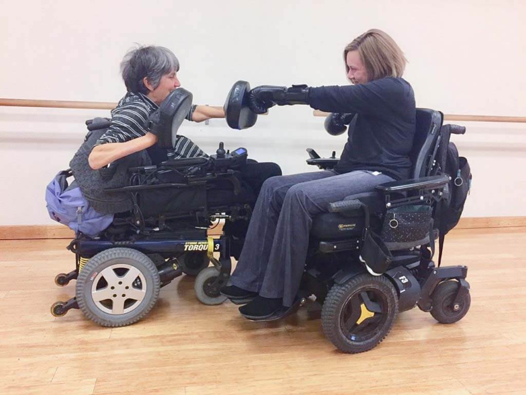 Two women wheelchair users practice boxing