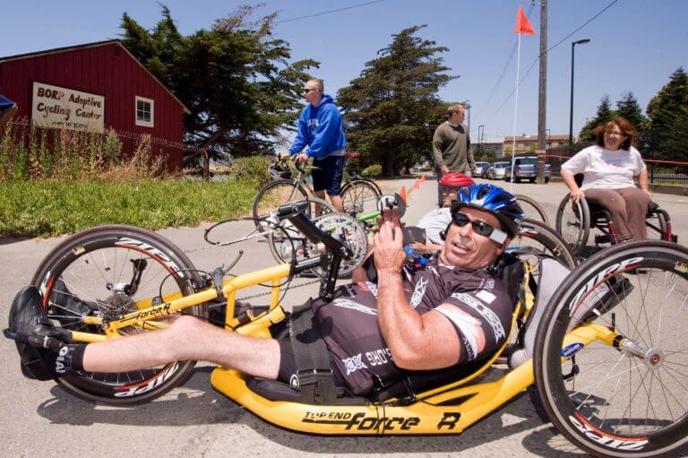Man on handcycle in front of BORP cycling center