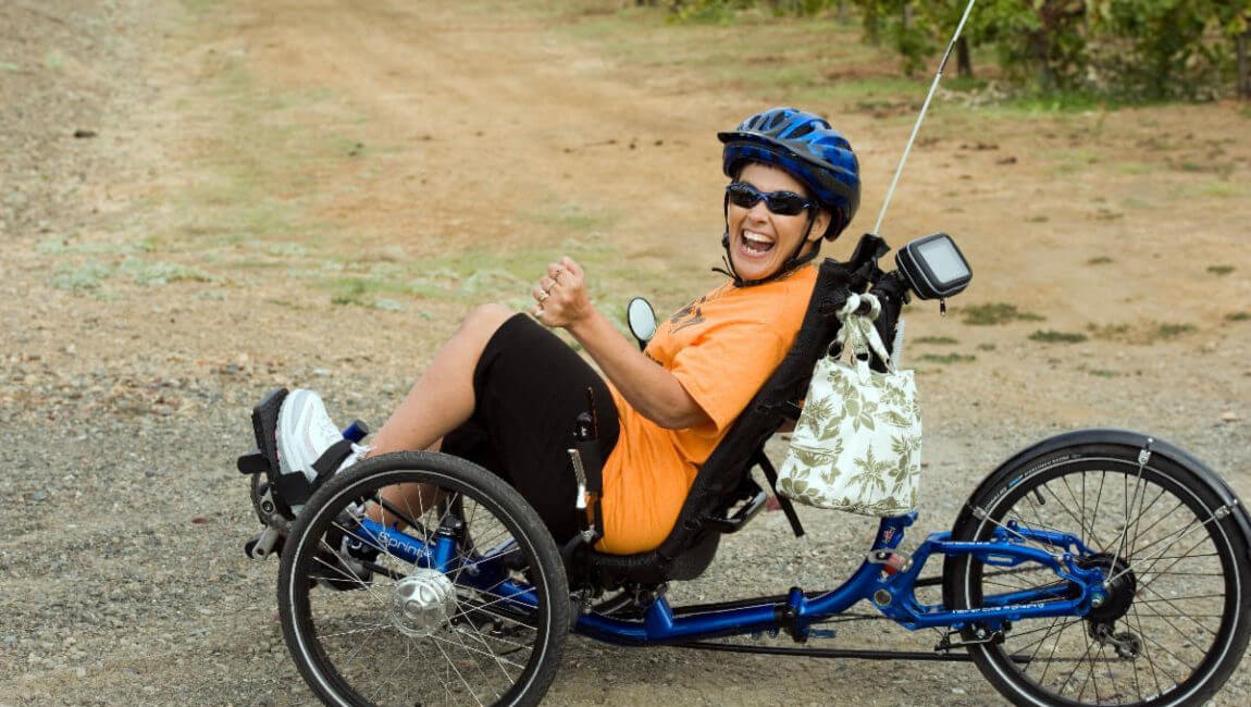 Woman on recumbent bike laughing as she looks at camera