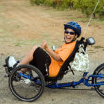 Woman on recumbent bike laughing as she looks at camera