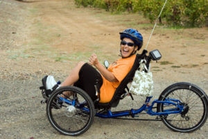 Woman on recumbent bike laughing as she looks at camera