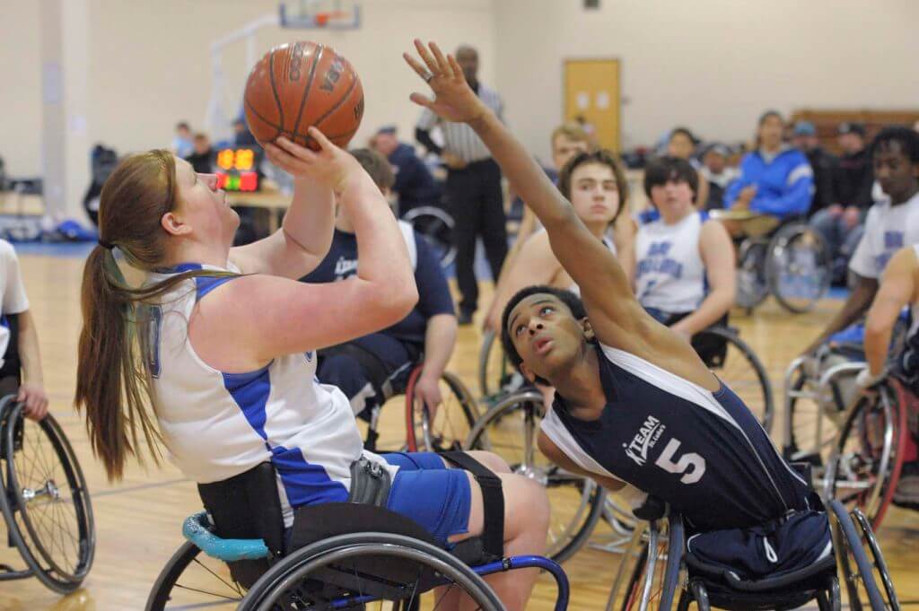 Young man challenges young woman basketball player for control of the ball