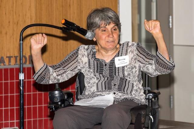 Bonnie Lewkowicz speaking at microphone