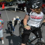 Person with a trail-a-bike wearing a 2003 Revolution Ride Jersey