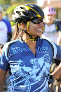 Rider with sun glasses wearing the 2013 Revolution Ride jersey with a big smile.