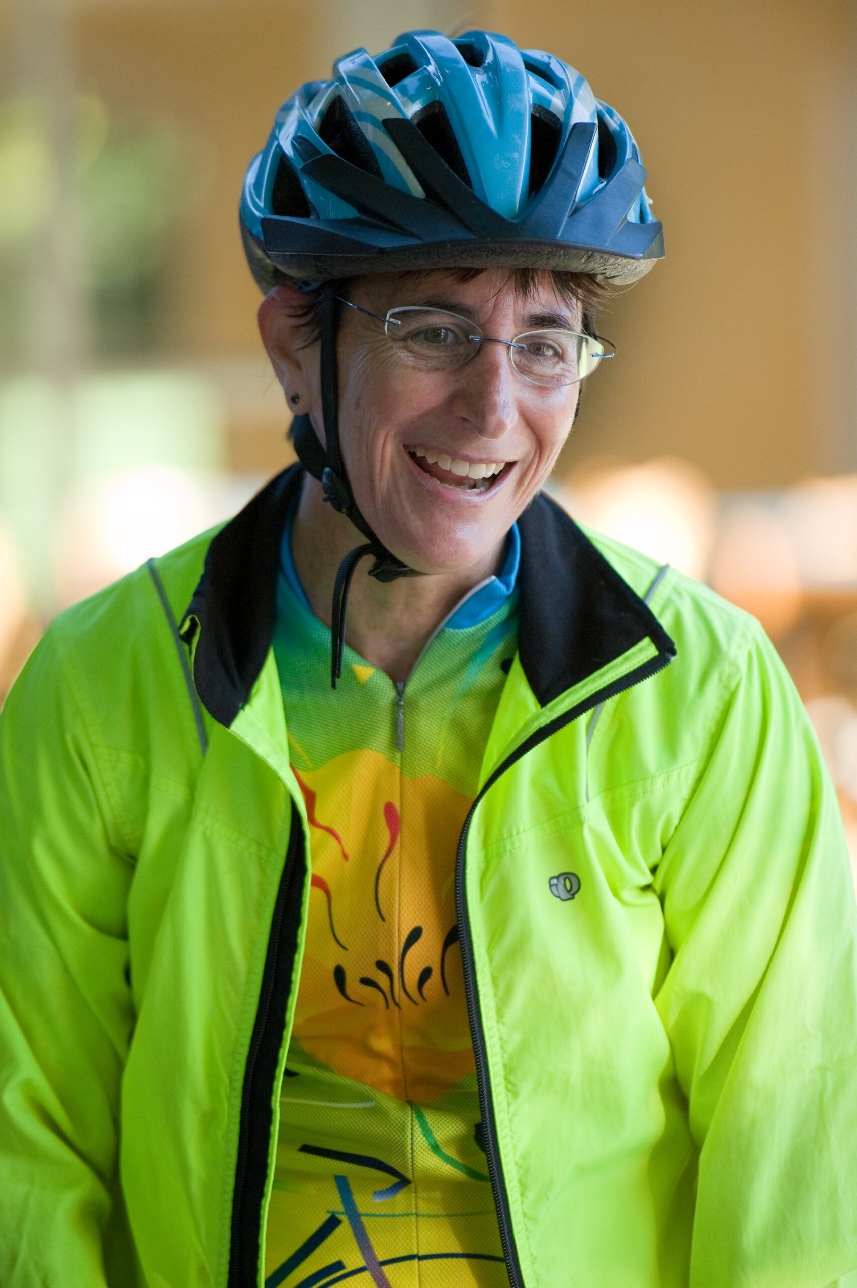 Woman wearing a green jacket over the 2015 Revolution Ride jersey.