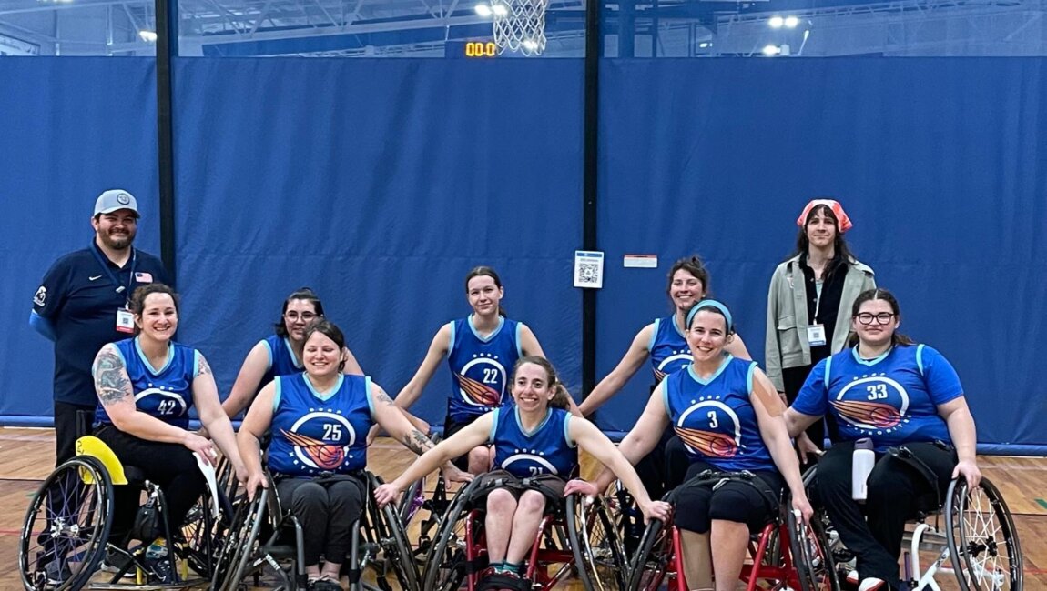 The meteorites, a group of 8 players, pose in sports chairs after their last game with arms linked and smiles.