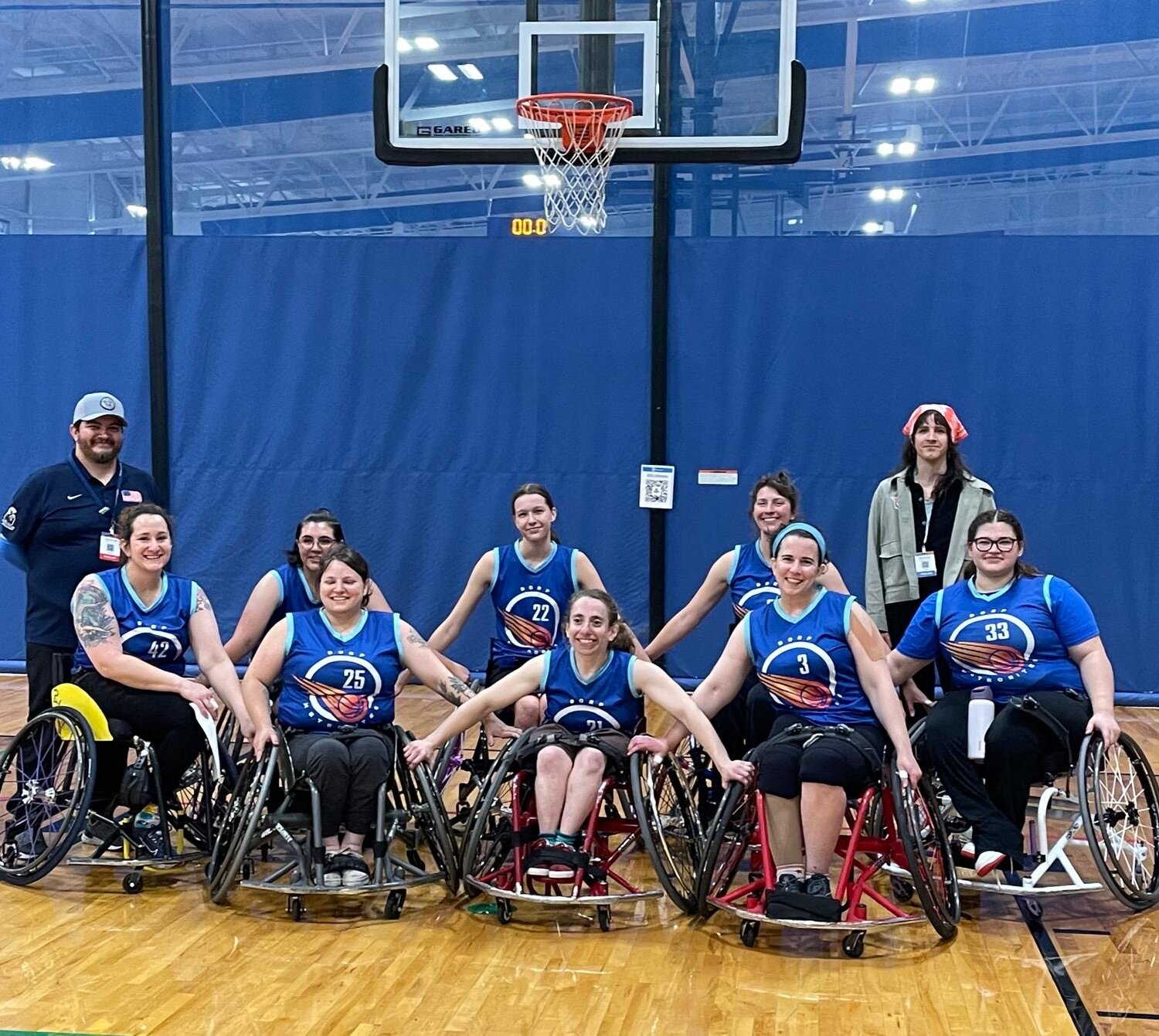 The meteorites, a group of 8 players, pose in sports chairs after their last game with arms linked and smiles.