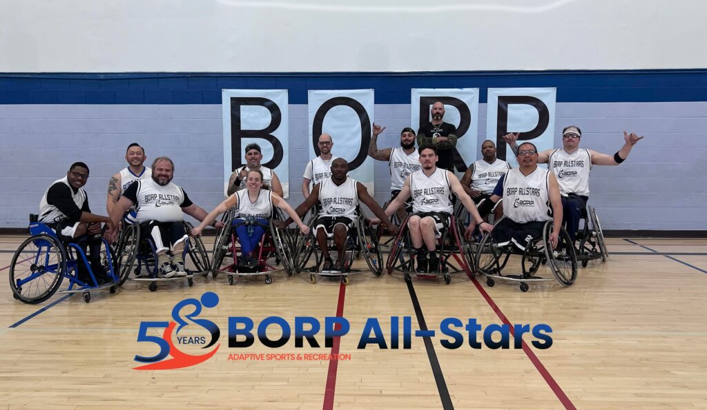Twelve basketball players using wheelchairs in white jerseys and one person standing pose in front of a BORP sign. Text below them reads BORP All Stars