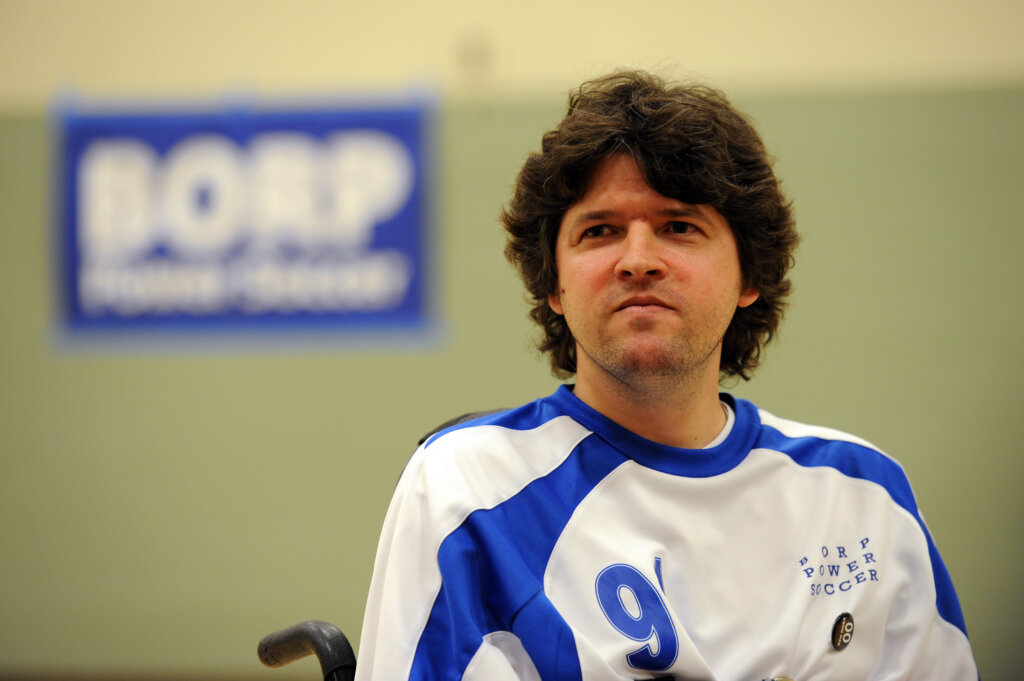 Face and shoulders of John Madigan - a white man with brown hair wearing a jersey that reads #9