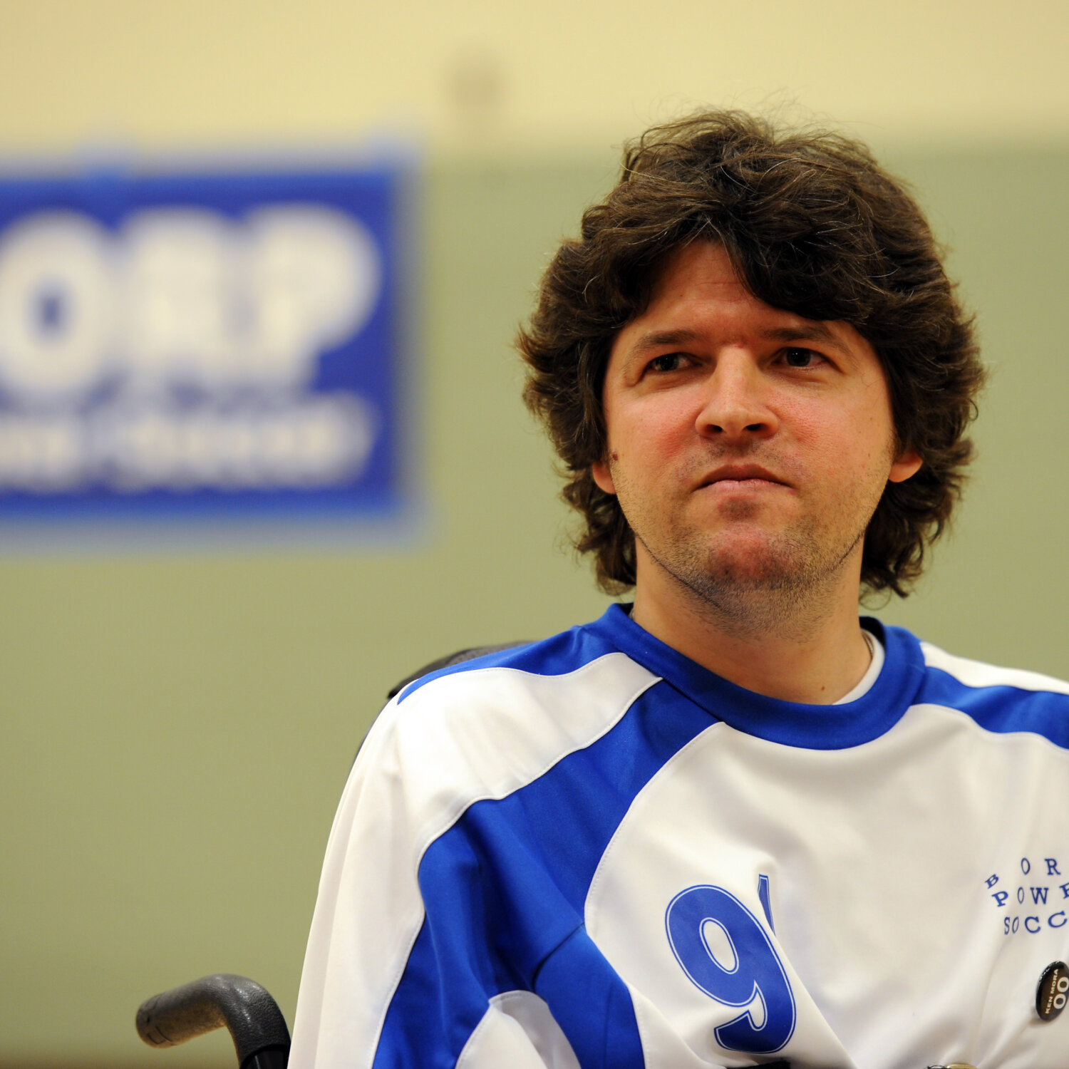 Face and shoulders of John Madigan - a white man with brown hair wearing a jersey that reads #9