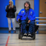 John Madigan with head set and using power chair