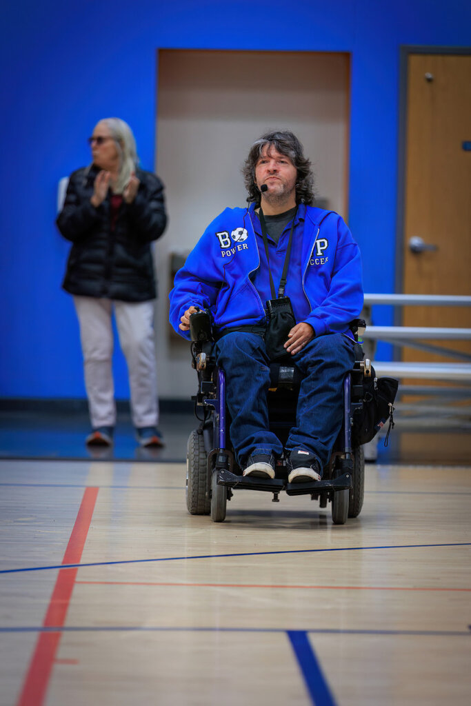 John Madigan with head set and using power chair