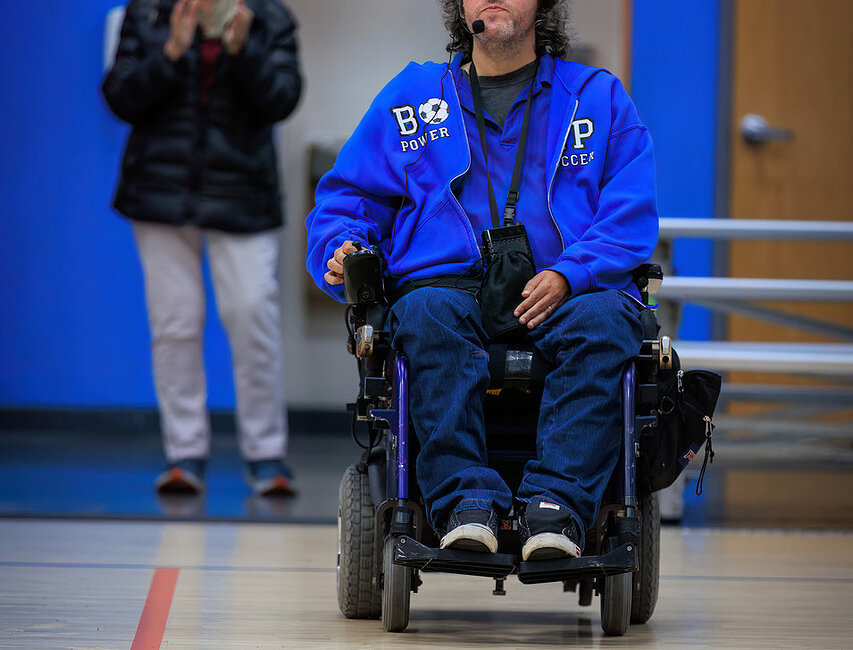 John Madigan with head set and using power chair